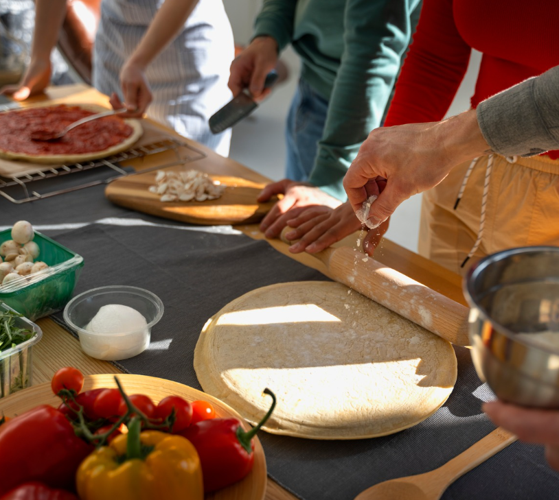Personnes préparant un repas à base de légumes frais sur une table en bois
